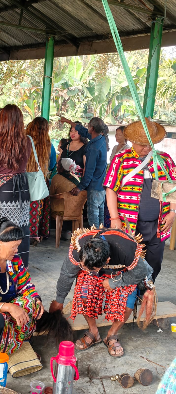Reh Festival ritual scene with Idu Mishmi priest and community members in traditional woven shawls