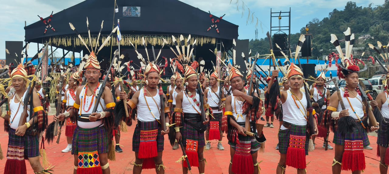 Nocte warriors in feathered headgear lined before the festival stage, Chalo Loku