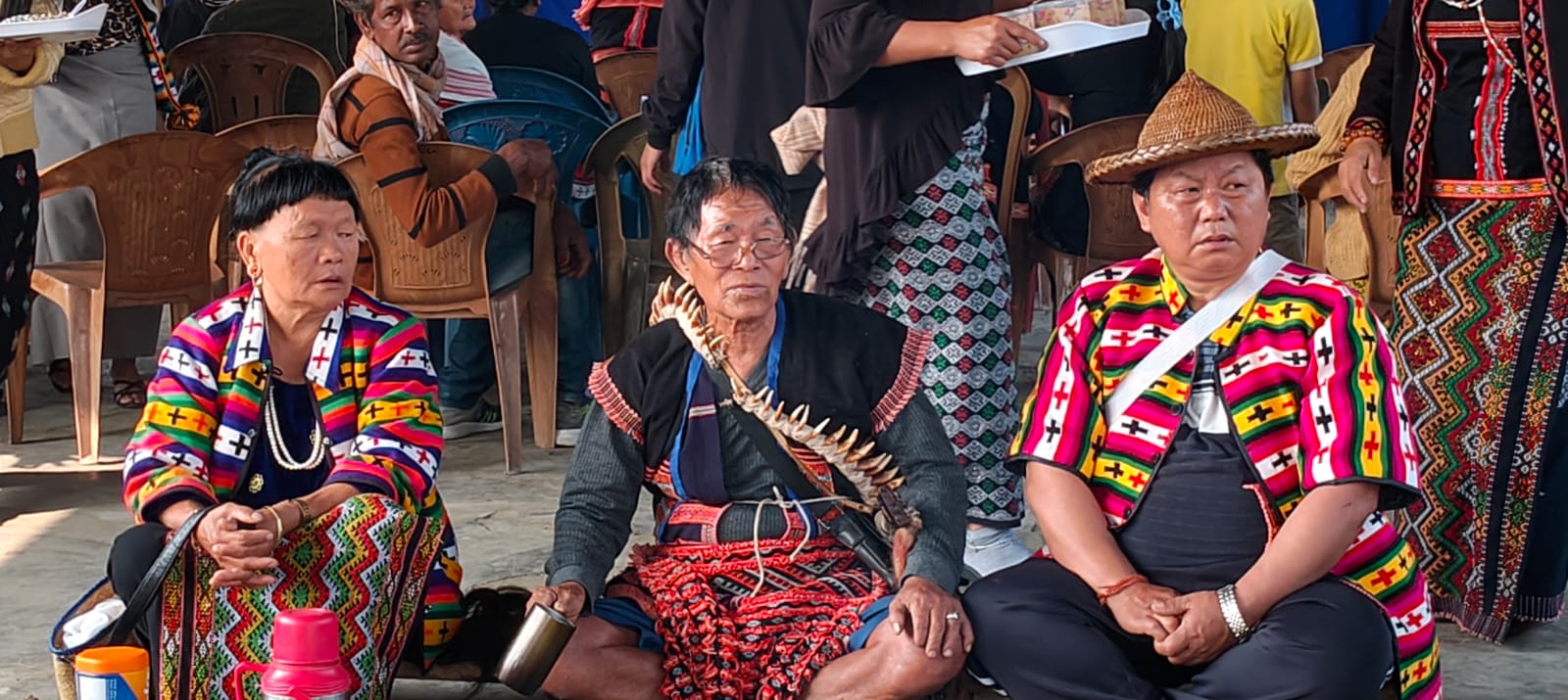 Idu Mishmi elders in traditional attire at the Reh Festival — the central elder wears a mithun-tooth necklace, Dibang Valley, Arunachal Pradesh